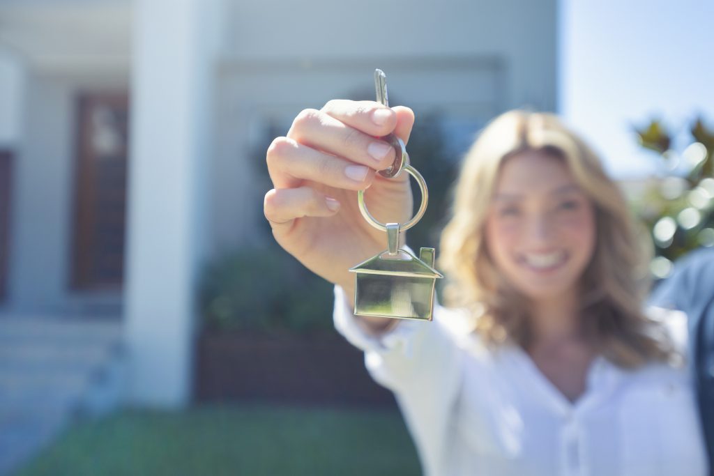 Young woman holding the key to her new house